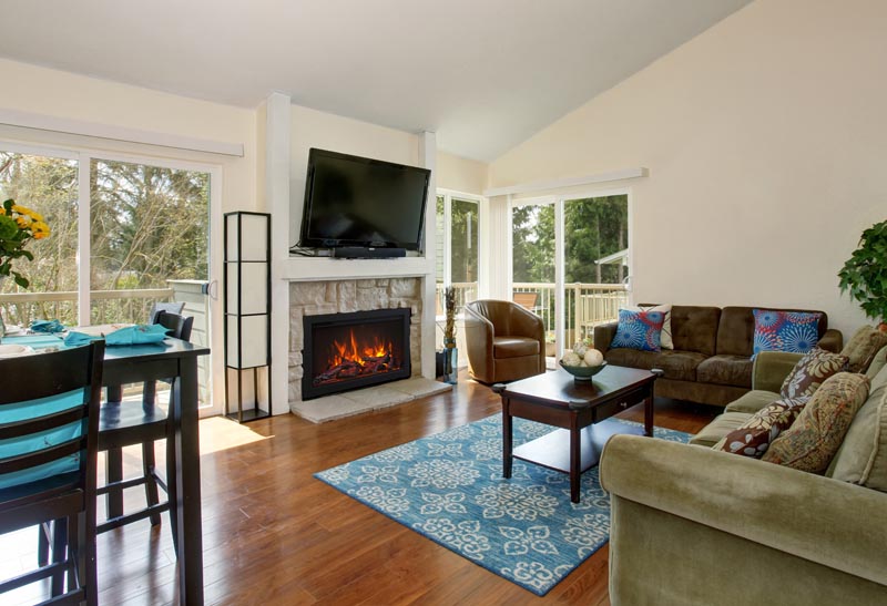 Excellent living room with blue rug and fireplace.